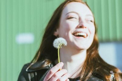 Portrait of a smiling young woman holding blue flower