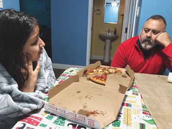 Happy friends sitting on table