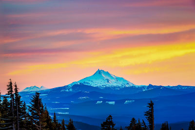 Scenic view of snowcapped mountains against sky during sunset