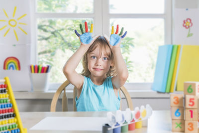 Portrait of girl on table at home