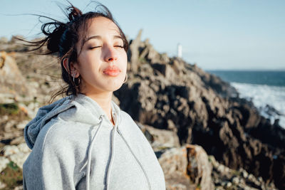 Portrait of young woman looking away at beach