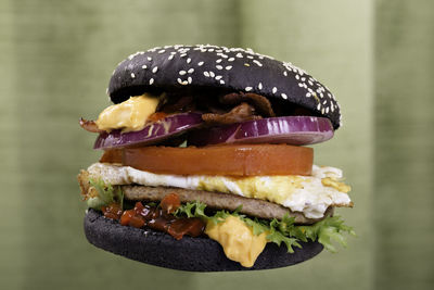 Close-up of black bun burger levitating