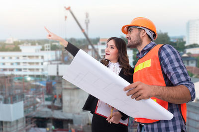 Young couple holding hands while standing at construction site