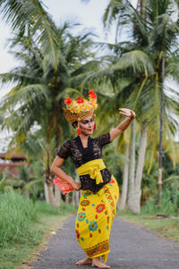 Woman in traditional clothing dancing on road