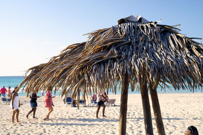 People at beach against clear sky