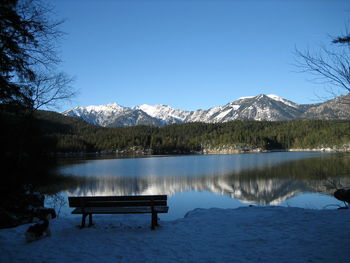 Scenic view of lake and mountains against clear blue sky