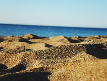 Surface level of beach against clear sky