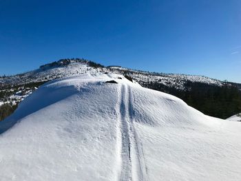 Scenic view of snowcapped mountains against clear blue sky