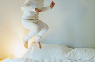 Child midair jumping on the bed