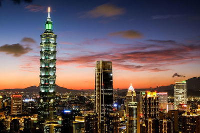 Illuminated buildings against sky at night