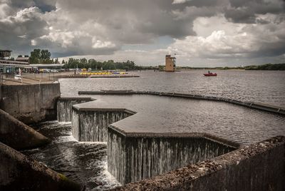 Scenic view of river against cloudy sky