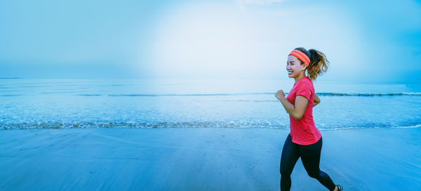 Portrait of young woman standing at beach