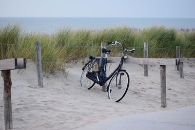 Bicycle on beach against sky