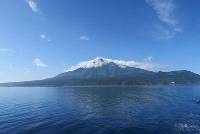 Scenic view of sea and mountains against blue sky