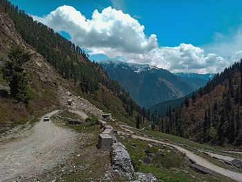 Panoramic view of road by mountains against sky