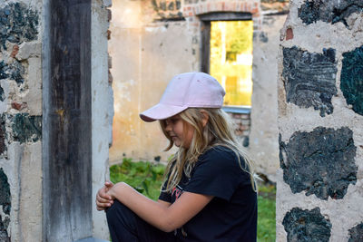 Side view of woman standing against built structure