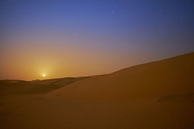 Scenic view of desert against sky at sunset