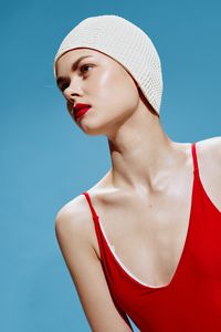 Low angle view of young woman looking away against blue background