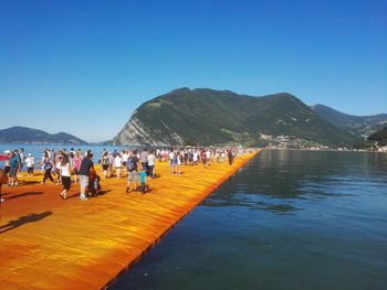 People on mountain against blue sky