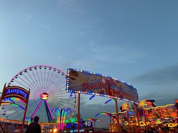 Low angle view of illuminated ferris wheel against sky