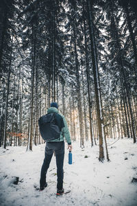 Rear view of man standing on snow covered land