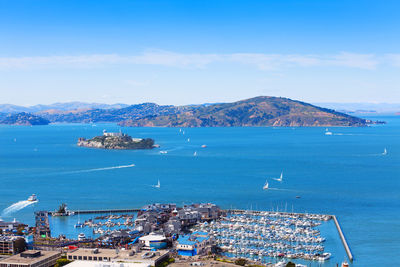 High angle view of city by sea against sky