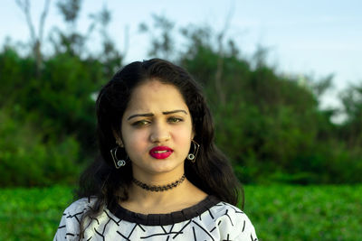 Portrait of young woman against plants