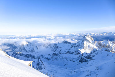 Scenic view of snowcapped mountains against blue sky