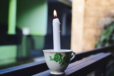 Close-up of lit candles on table against building