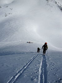 People skiing on snowcapped mountain during winter