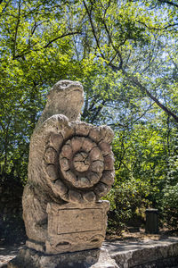 Close-up of statue against trees in forest