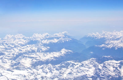 Scenic view of snowcapped mountains against blue sky