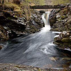 Scenic view of waterfall against sky