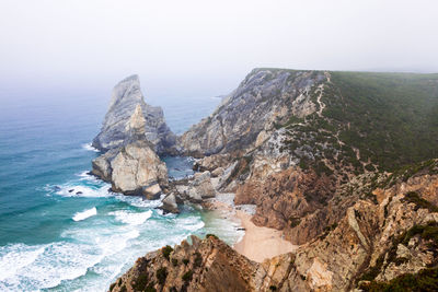 Scenic view of sea and rocks against sky