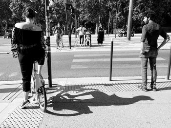 Rear view of people walking on road