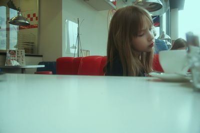 Portrait of young woman sitting on table