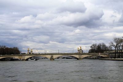 Arch bridge over river against sky