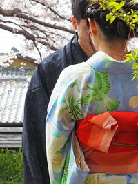 Rear view of woman wearing kimono standing by man