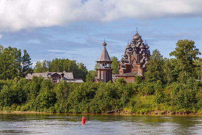 Plants by river and building against sky