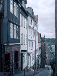 Residential buildings by street against sky