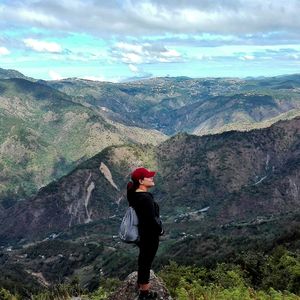 View of woman standing on mountain against sky