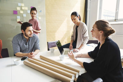 Mature businesswoman discussing with colleagues at conference table