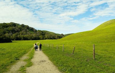 People walking on field against sky