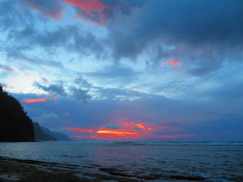 Scenic view of sea against dramatic sky during sunset