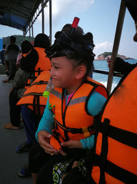 Cute girl wearing life jacket sitting in ferry