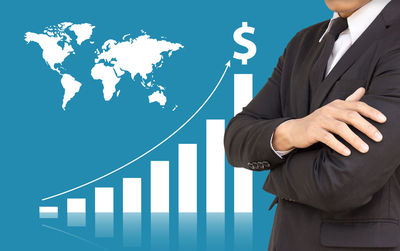 Digital composite image of businessman standing against graph