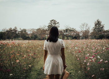 Rear view of woman standing on field