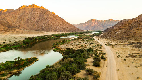 Scenic view of landscape and mountains against clear sky