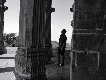 Side view of man standing amidst columns at palace