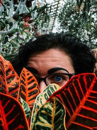 Close-up portrait of young woman holding leaves